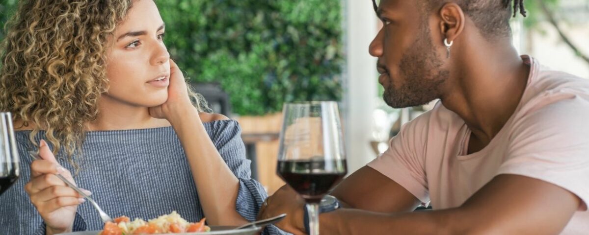 Un homme au restaurant qui demande des conseils pour booster votre charisme avant un rendez-vous amoureux