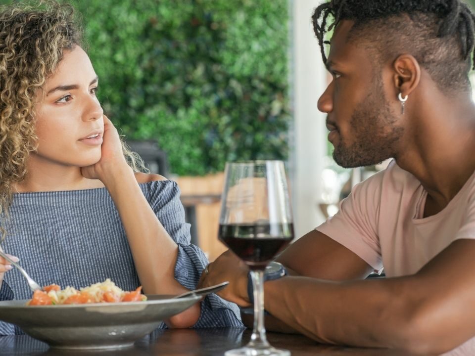 Un homme au restaurant qui demande des conseils pour booster votre charisme avant un rendez-vous amoureux