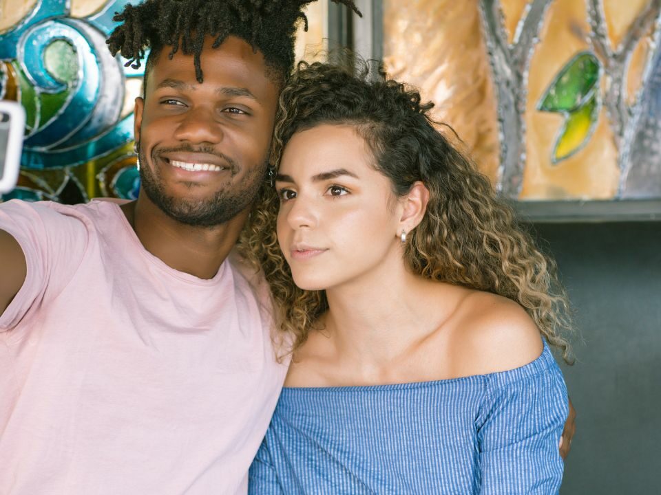 Un couple metis qui prend un selfie après leur dating sur le site de rencontre métisse