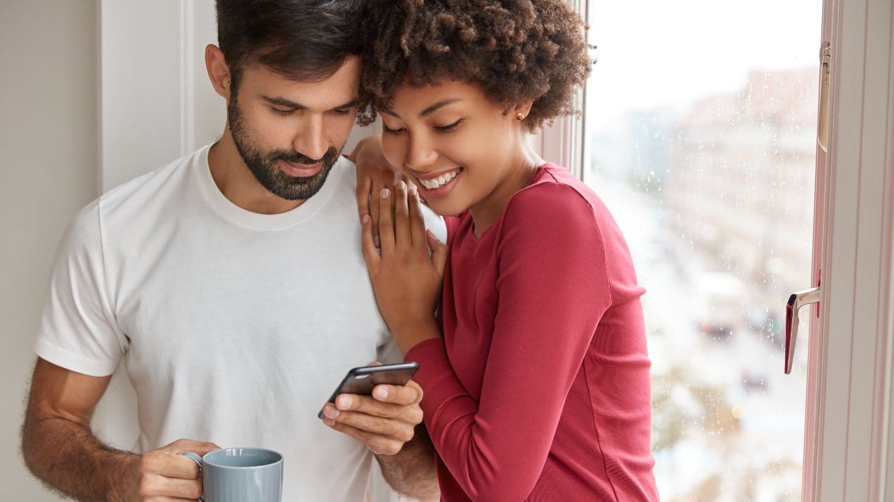 2 personnes qui regardent une application de rencontre sur le même smartphone