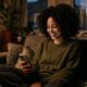 Femme métisse souriant en discutant sur une appli avant de savoir quand se voir après une rencontre en ligne