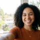 Femme métisse prenant une photo profil site de rencontre avec de la lumière naturelle